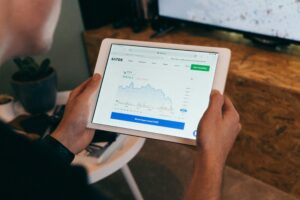 Marketer analyzing live financial data on a tablet, representing real-time analytics, closed-loop marketing, and Zeekeo’s data-driven growth engine in 2025.